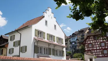 Historisches Gebäude mit weiss verputzter Fassade in saniertem Zustand