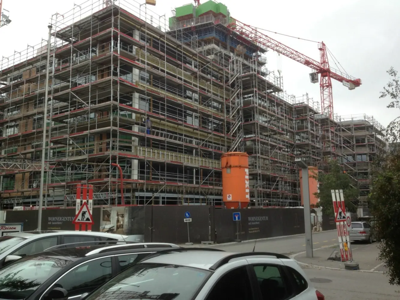 Eingerüstetes Gebäude mit orangenen Fixit Silo und Kran