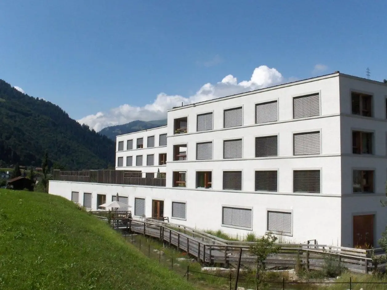 Bâtiment vu depuis la pente, baigné de soleil