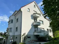 La facciata dell'edificio con i piccoli balconi illuminati dal sole
