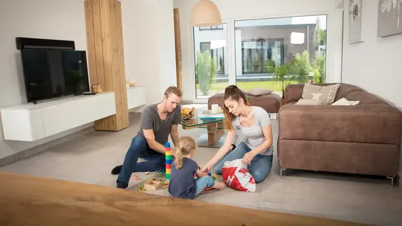 Eltern spielen mit ihrem Kind im Wohnzimmer 
