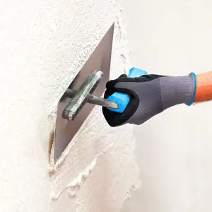 Ein Oberputz wird auf eine Wand aufgetragen.
