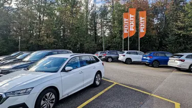 Voitures garées sur le parking de l'administration de Holderbank avec des drapeaux Fixit en arrière-plan