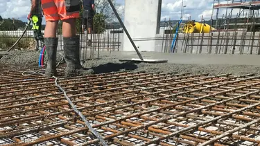 Stahlarmierungsgitter auf einem Aussenfundament werden mit Spritzbeton verfüllt.