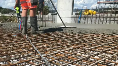 Stahlarmierungsgitter auf einem Aussenfundament werden mit Spritzbeton verfüllt.