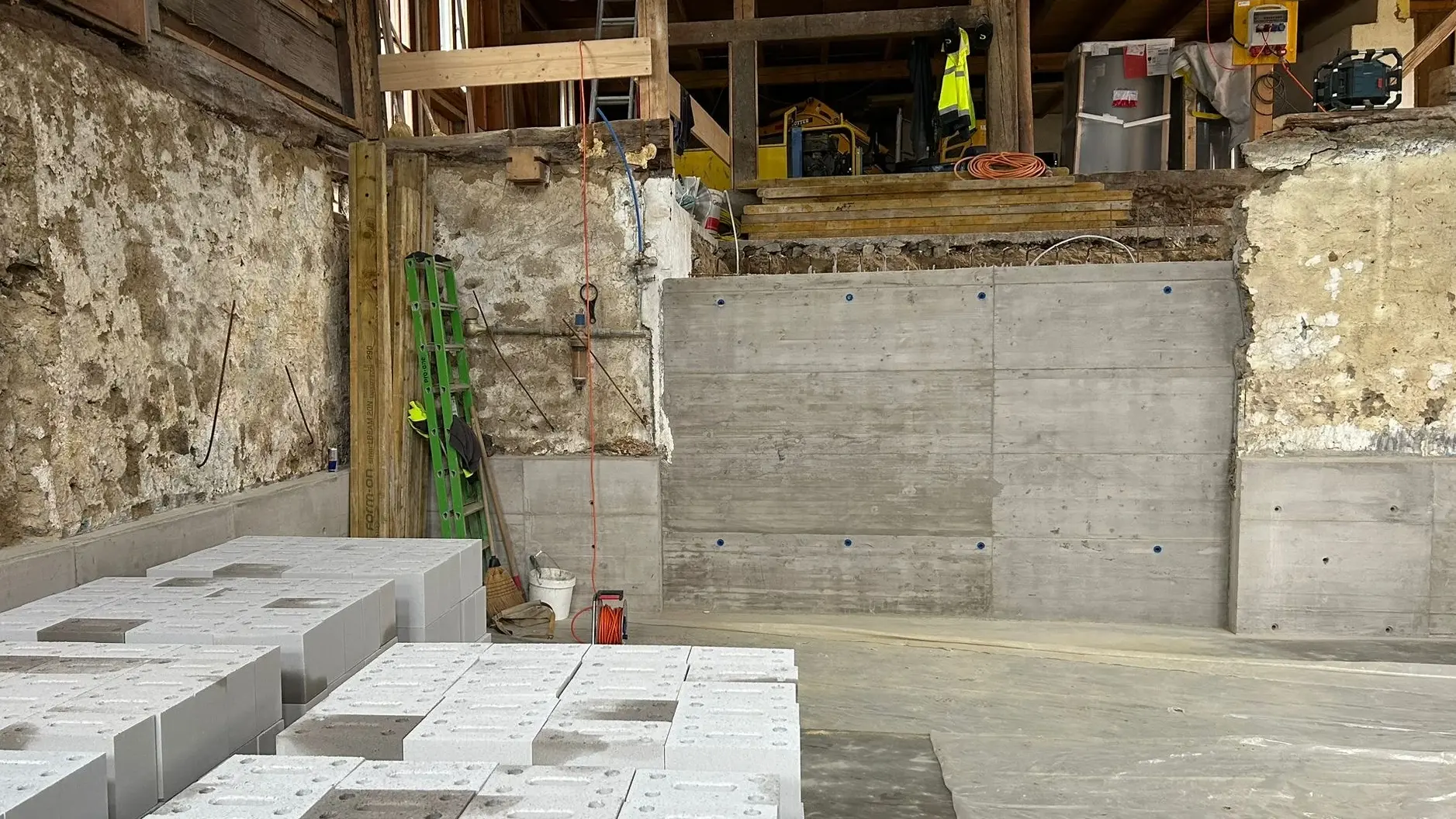 Intérieur avec un nouveau mur en béton et des renforts sous l'ancienne maçonnerie