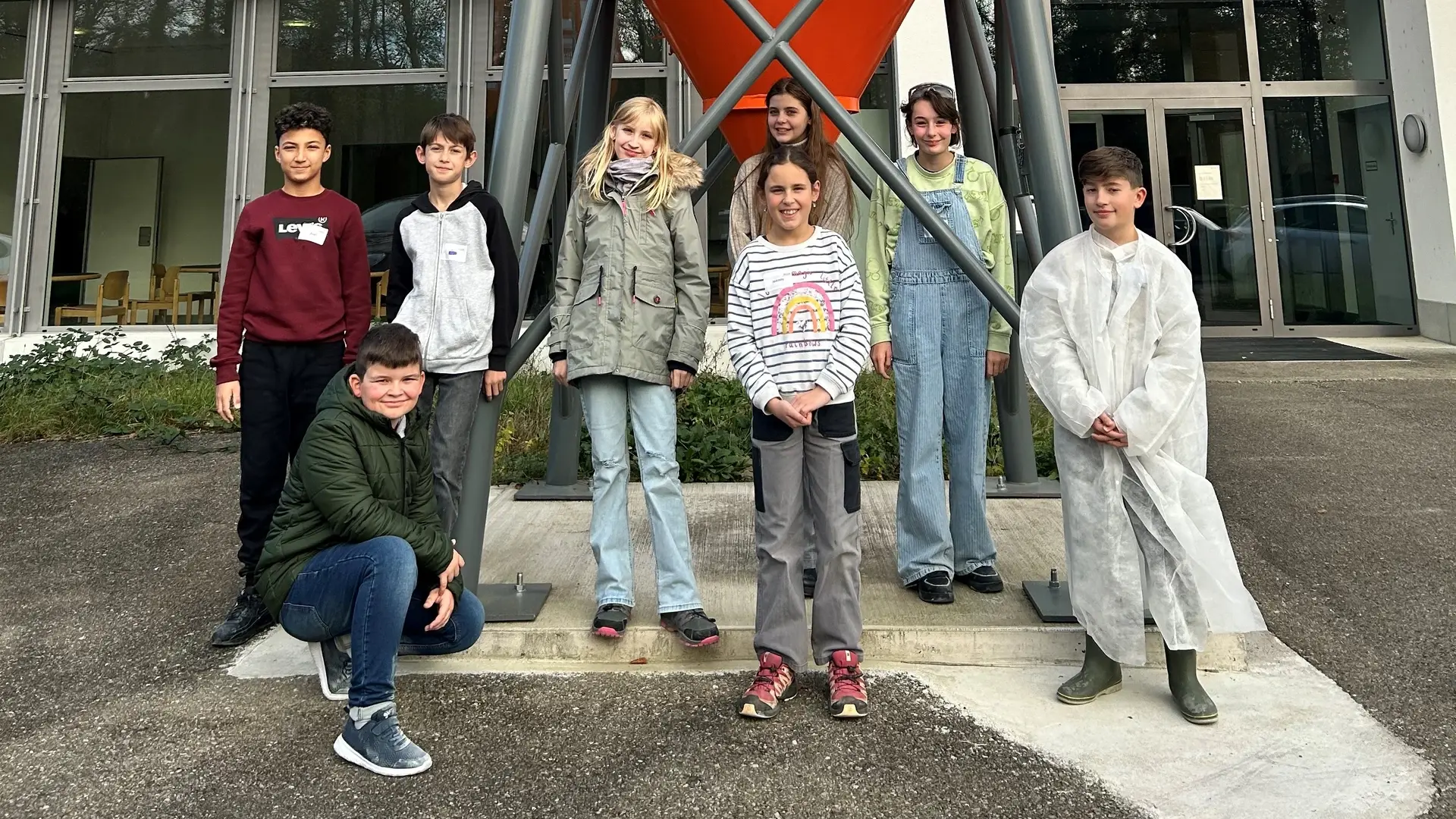 Gruppenfoto der neun teilnehmenden Kinder am Zukunftstag bei Fixit in Holderbank vor dem Jubiläumssilo am Verwaltungsgebäude