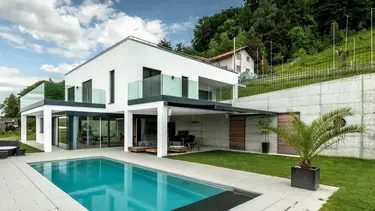 Maison individuelle moderne avec piscine et façade extérieure crépie en blanc avec système composite d'isolation thermique