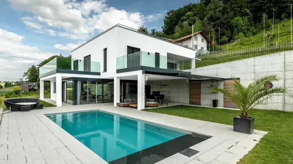 Modernes Einfamilienhaus mit Pool und weiss verputzter Aussenfassade mit Wärmedämmverbundbsystem