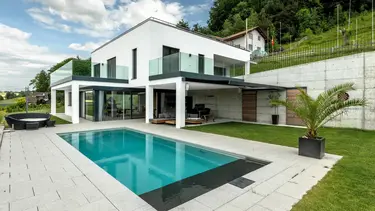 Modernes Einfamilienhaus mit Pool und weiss verputzter Aussenfassade mit Wärmedämmverbundbsystem