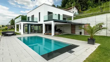 Maison individuelle moderne avec piscine et façade extérieure crépie en blanc avec système composite d'isolation thermique