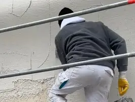 Arbeiten an der Fassade – Aufbringen des Oberputzes auf der Baustelle
