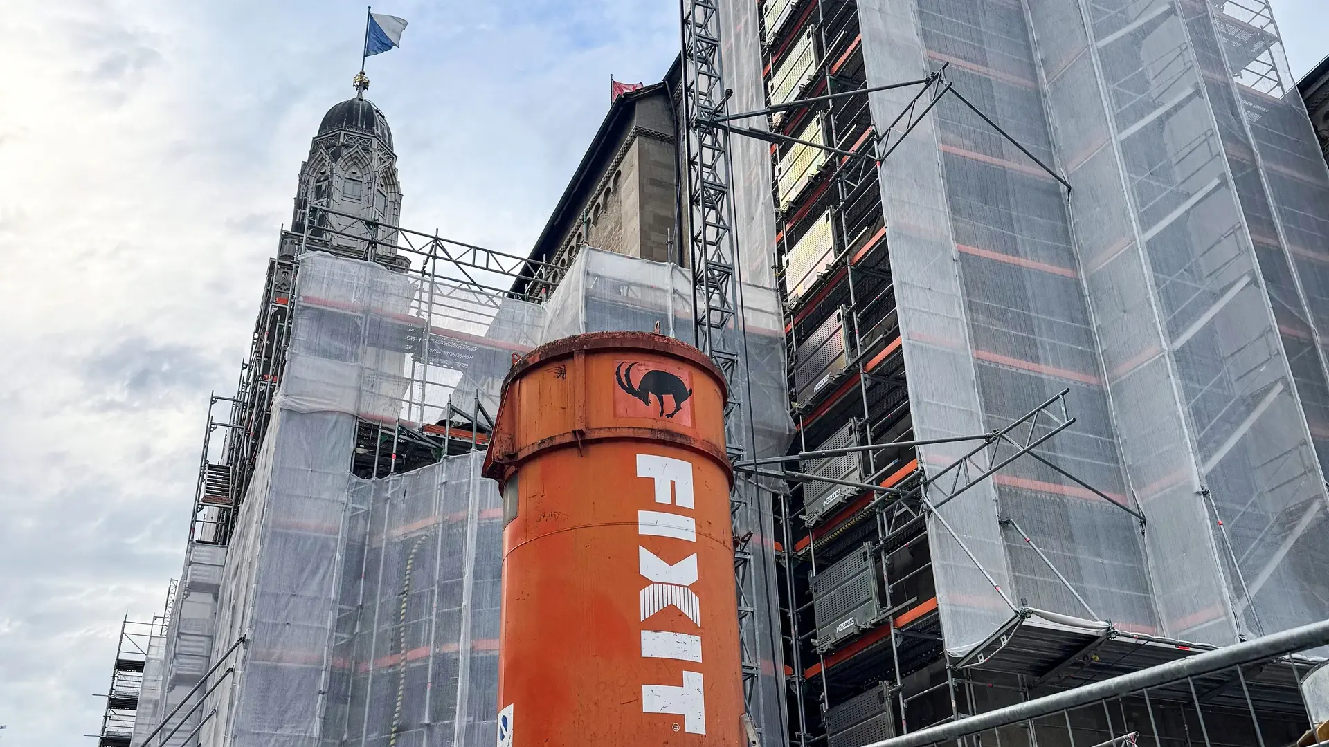 Orangenes Fixit Silo vor dem eingerüsteten Grossmünster in Zürich Oberdorf