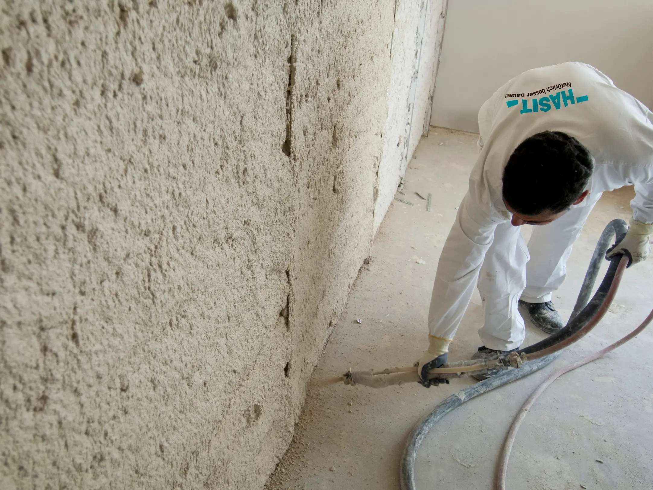 Dämmputz wird auf eine Wand gespritzt.