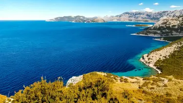 Küstenregion in Kroatien mit blauem Meer und bewaldeten Berghängen, KI generiert
