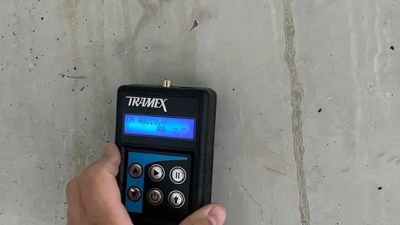 Détail de l'appareil de mesure Tramex sur un mur en béton avec un bon résultat de mesure de la valeur d'humidité
