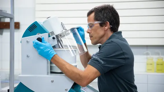 Collaborateur de laboratoire sur un agitateur lors d'un processus de contrôle