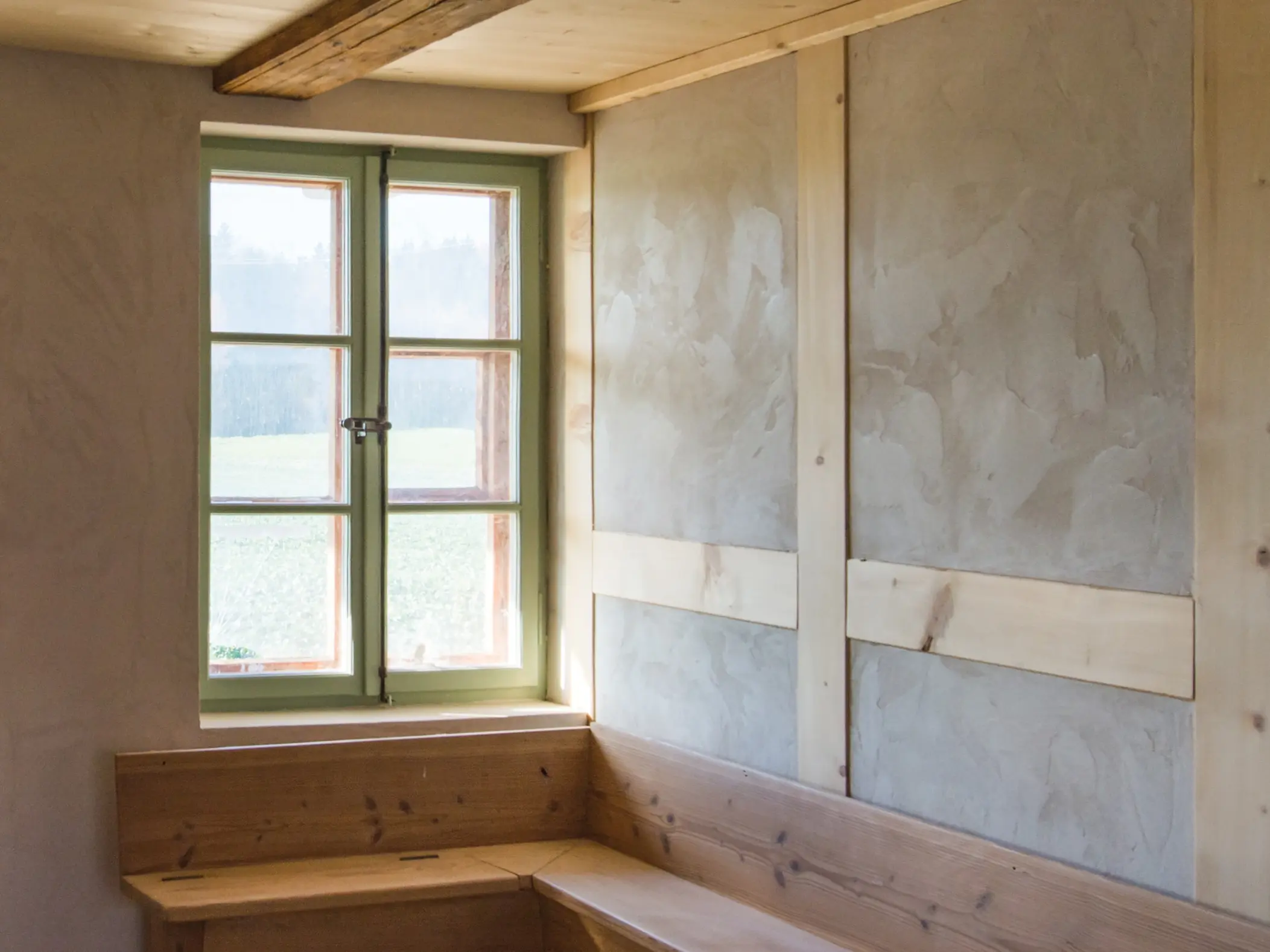 Intérieur avec fenêtre à croisillons et banc en bois, éléments à colombages apparents dans le mur