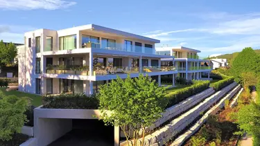 Immeuble moderne avec grands balcons à Hofberg avec façade extérieure individuelle : crépi combiné avec une maçonnerie apparente en pierre naturelle