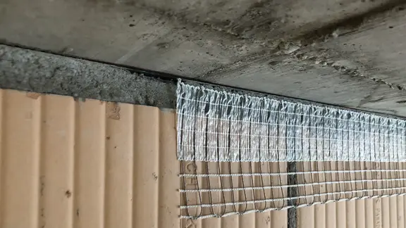 Stucanet® Easy Fix Entkopplungsband mit selbstklebendem Band auf das Mauerwerk aufgeklebt, bereit zum Verputzen