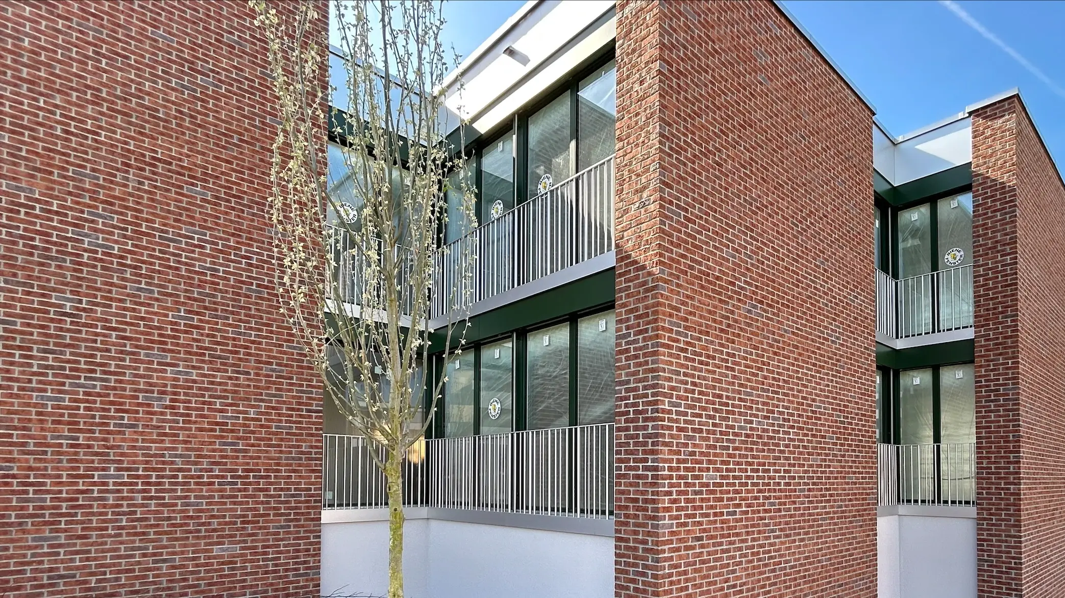 Seitenansicht der versetzt stehenden Gebäude mit der roten Klinkerfassade aus Sichtmauerwerk