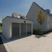 Fassadenperspektive mit Schwerpunkt auf den Garagen des Mehrfamilienhauses 