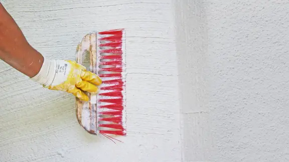 Struktur mit einem Besen auf die Wand bringen