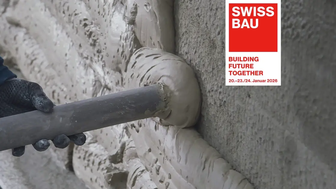 Gros plan de la buse de pulvérisation FOME® sur le mur et logo Swissbau
