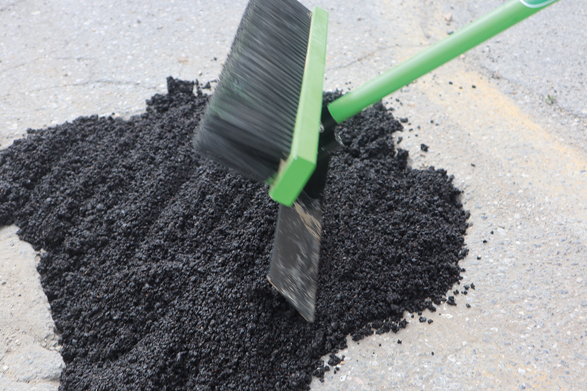 Der Kaltasphalt wird auf den Boden verteilt