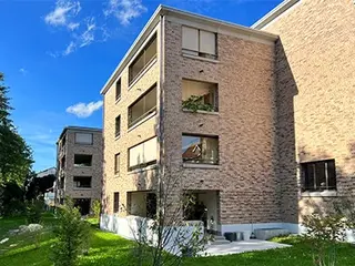Titelbild der Fixit Preisliste 2024 mit modernem Gebäude mit Sichtmauerwerk