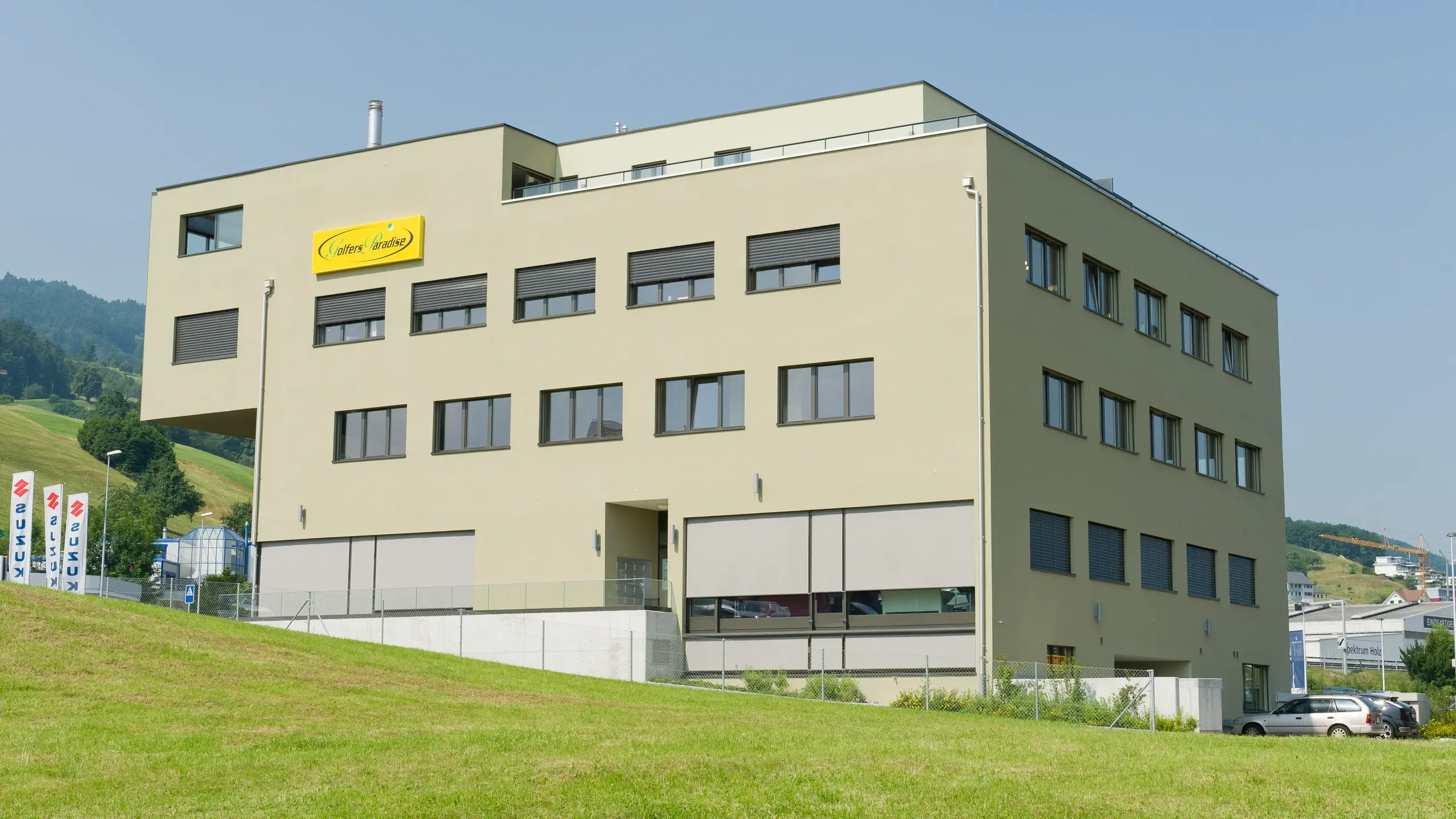 Kubisches, mehrstöckiges Gewerbegebäude mit grünlichem Putz