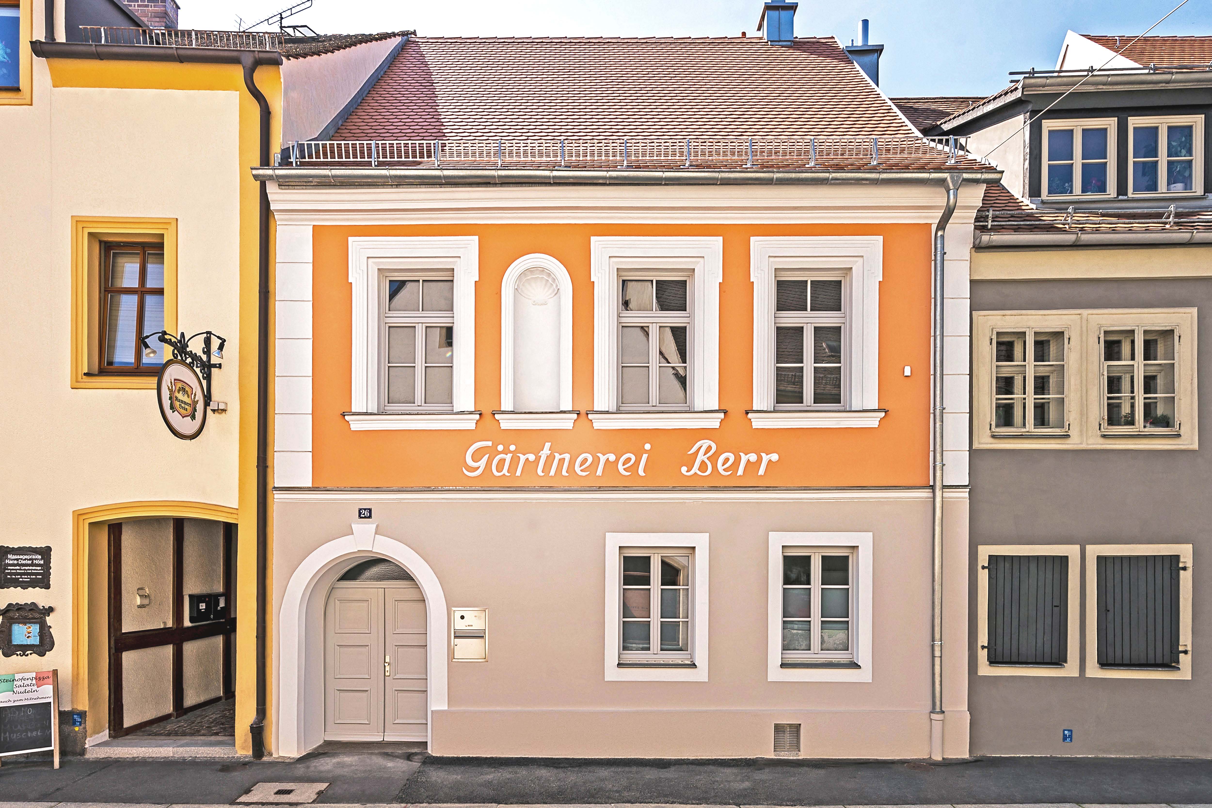 [Translate to English:] Farbenintensiv saniertes Gebäude in der Altstadt