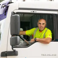 Ein LKW-Fahrer schaut aus dem Fenster seines Lastwagens.