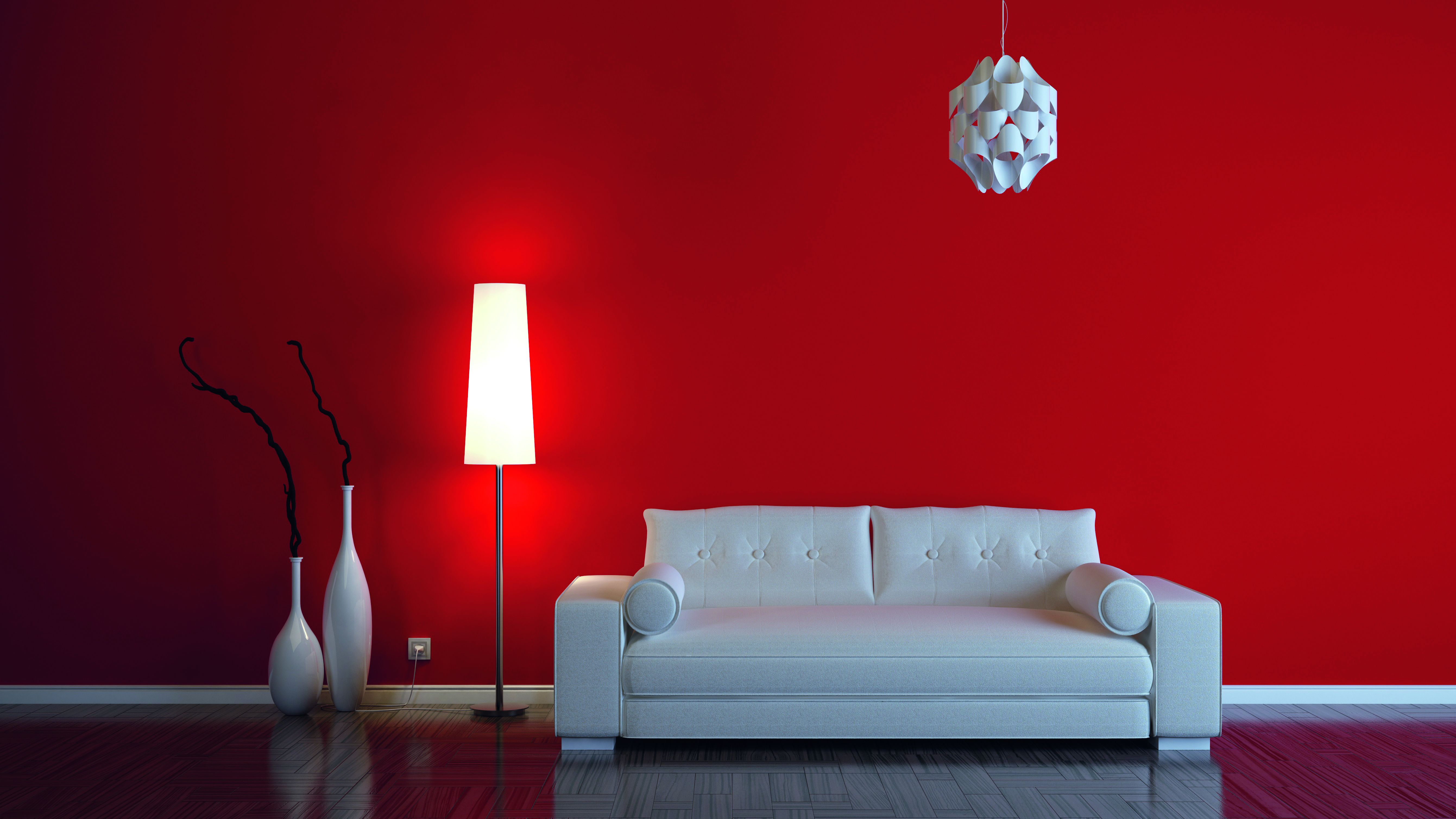 Der Wohnbereich mit einer roten Wand im Hintergrund des Sofas schafft einen lebendigen und einladenden Akzent