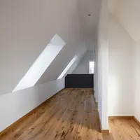 Dachfenster und Gauben bringen viel Licht in die Innenräume der modern wirkenden Dachgeschosswohnung