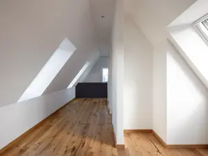 Dachfenster und Gauben bringen viel Licht in die Innenräume der modern wirkenden Dachgeschosswohnung