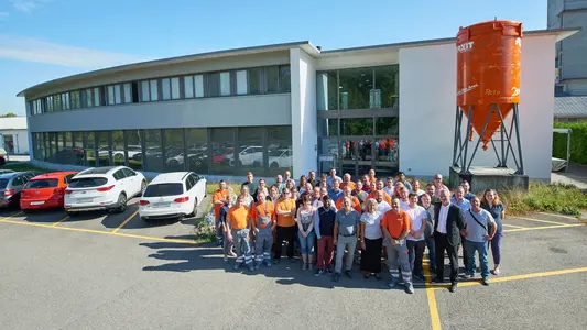 Fixit AG Gruppenfoto aller Mitarbeiter am Standort in Holderbank AG vor dem Verwaltungsgebäude mit Fixit Silo