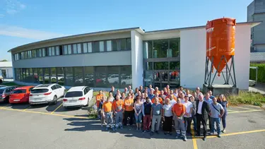 Fixit AG Gruppenfoto aller Mitarbeiter am Standort in Holderbank AG vor dem Verwaltungsgebäude mit Fixit Silo