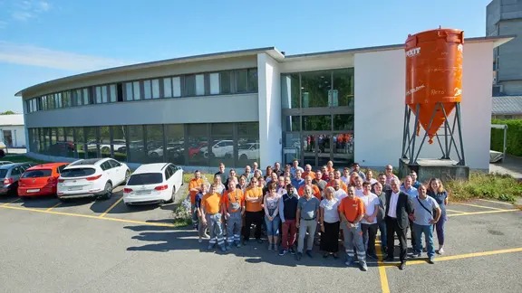 Fixit AG Photo de groupe de tous les collaborateurs du site de Holderbank AG devant le bâtiment administratif avec le silo Fixit