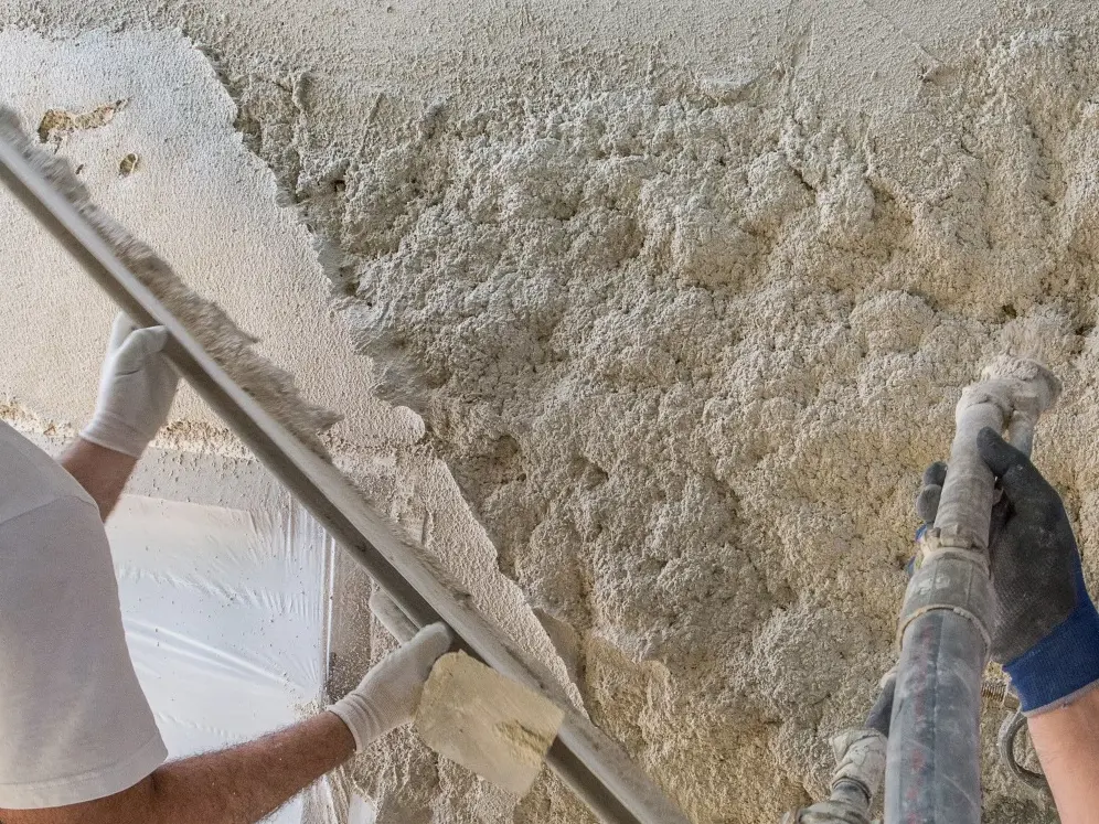Zwei Verarbeiter spritzen den Fixit 222 Aerogel Dämmputz an die Wand und ziehen ihn mit der Latte ab