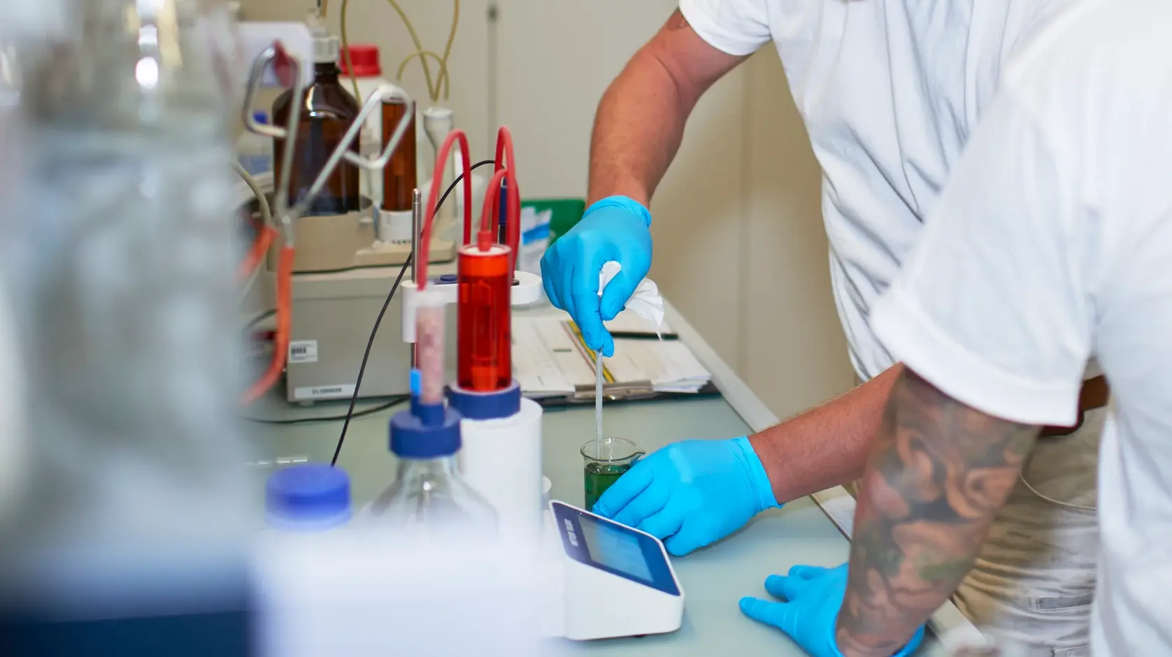 Zwei Mitarbeiter arbeiten im Labor an einem Messgefäss mit Pipette