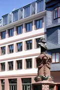 Perspektive auf die Seite des renovierten Objekts in Frankfurt mit einer Statue im Vordergrund