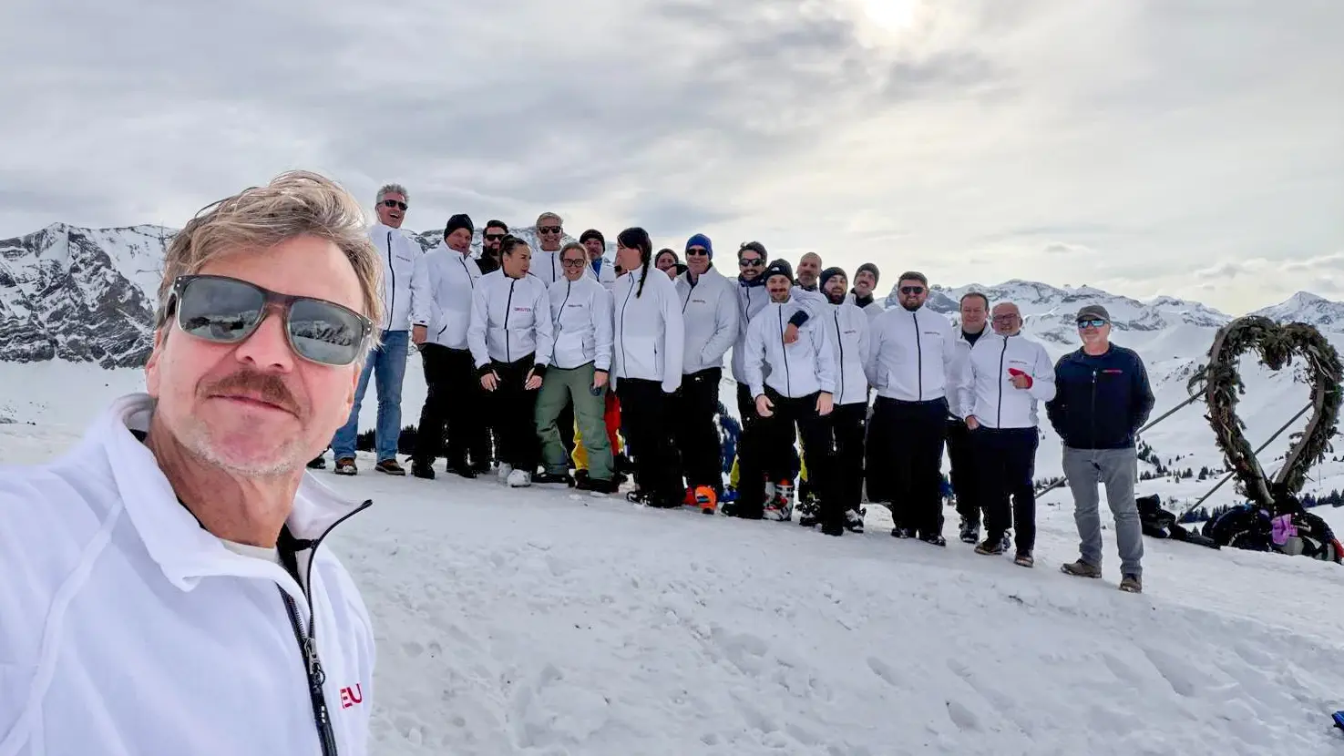 Urs Diggelman links im Vodergrund und dahinter das Greutol-Vertriebsteam auf der Skipiste als Gruppe