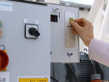  Eine Hand wirft eine Wertmarke in den Münzautomaten