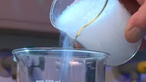 Das hochwertige Aerogel Granulat wird von einem Messbecher aus Glas in ein anderes Gefäss eingefüllt.