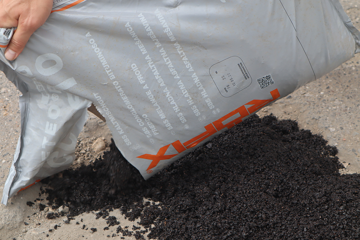 Kaltasphalt wird auf den zu reparierenden Boden aufgetragen