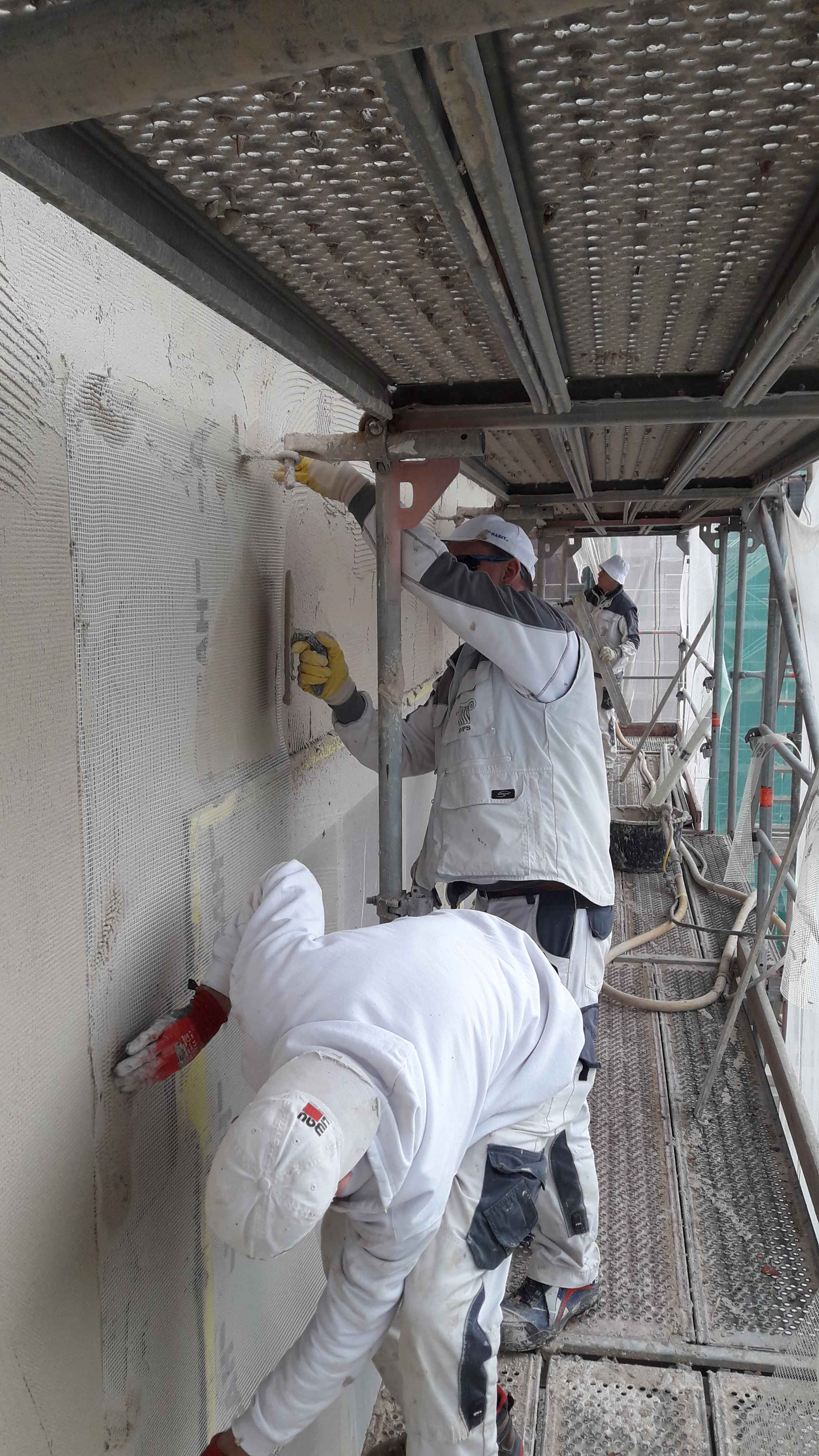 Arbeiter verputzen eine Außenwand 