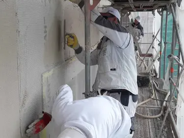 Arbeiter verputzen eine Außenwand 