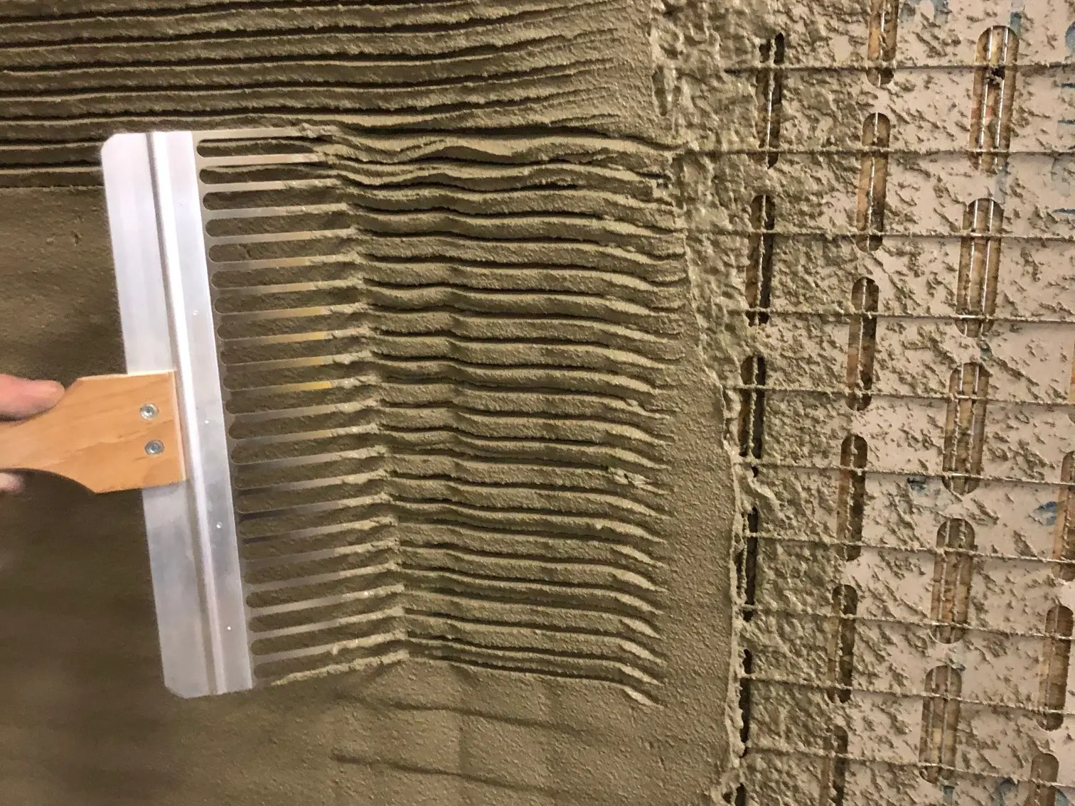 Stucanet® 33 wird auf der linken Seite mit einem Putzkamm aufgekämmt