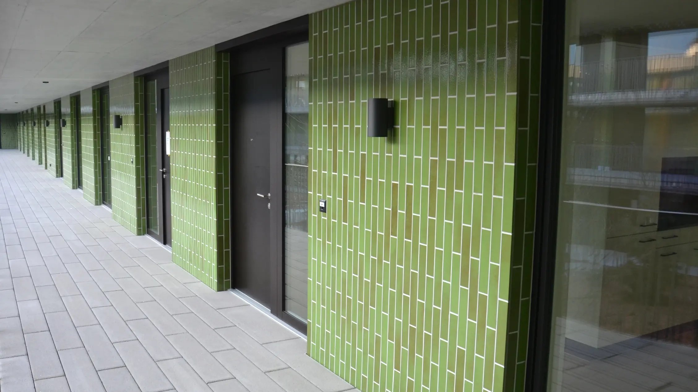 Detailaufnahme vom Eingangsbreich eines Mehrfamilienhauses mit grünen Fliesen auf WDVS dank Fixit StoneEtics®